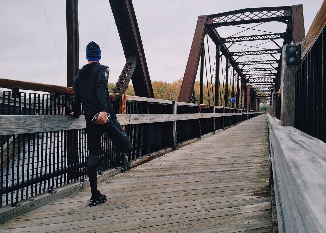 Man stretches on bridge before going for a run